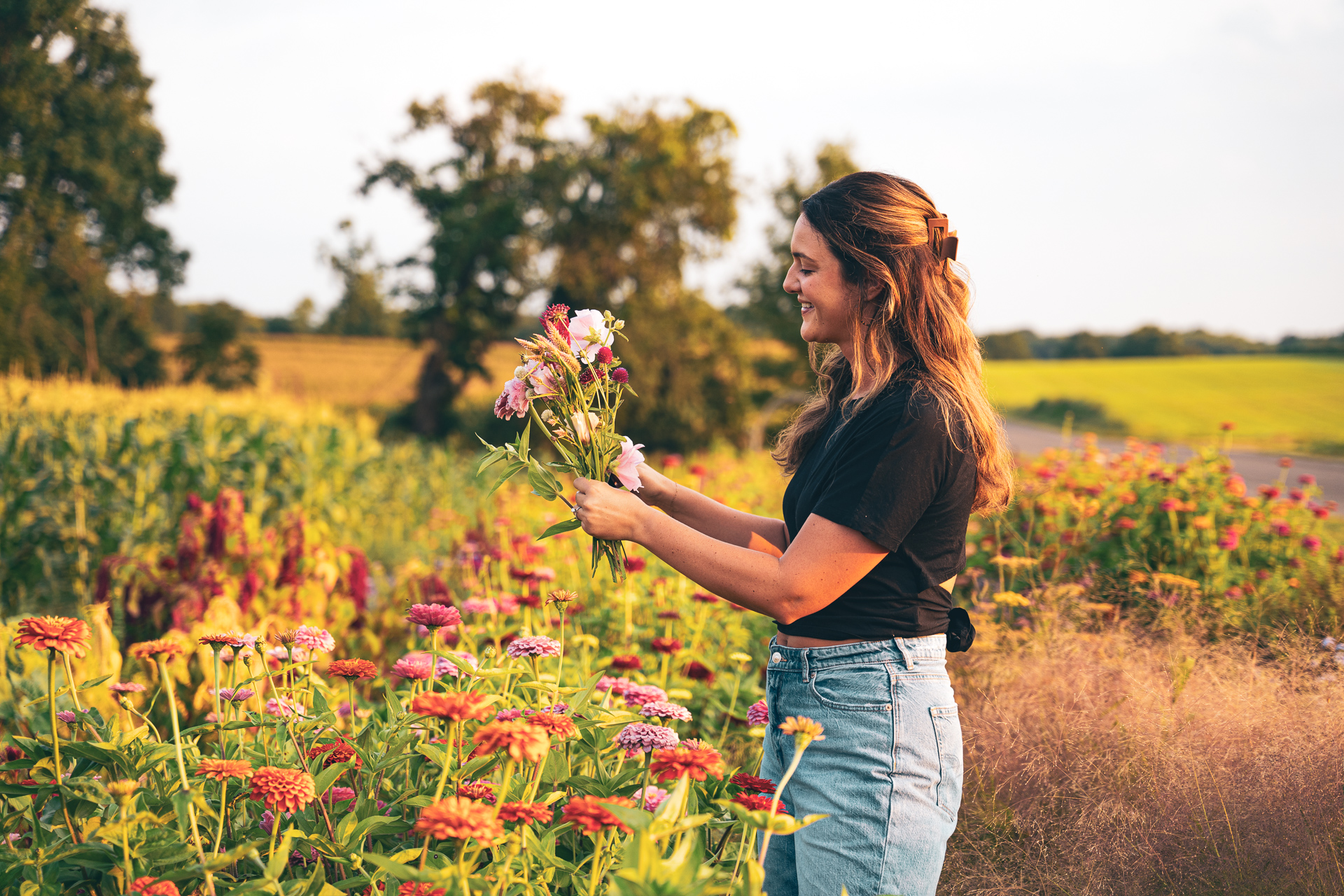A woman arranging flowers in the field at golden hour