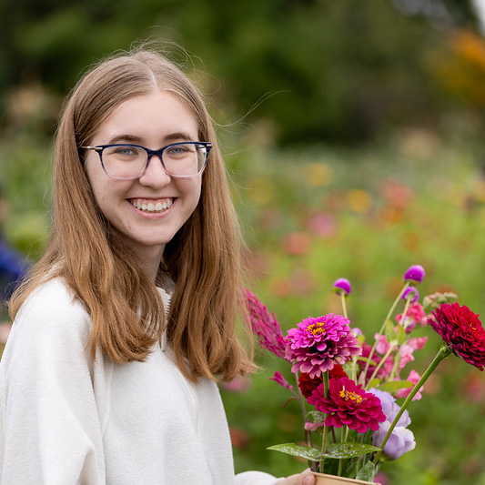 A college student picking flowers on the farm